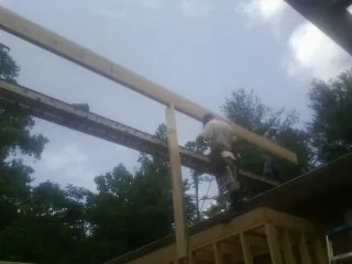 Carpenter setting a ridge beam over a new addition frame — Ice Dam Removal by Roofing Brothers in Camas