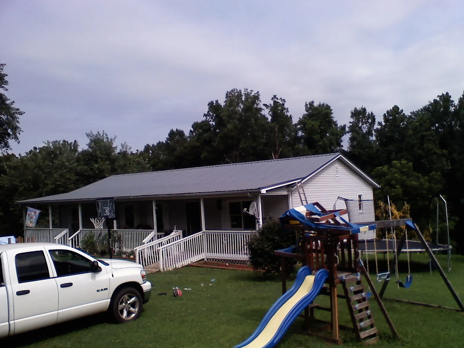 Dark metal roof on a country home with a full length front porch in Camas