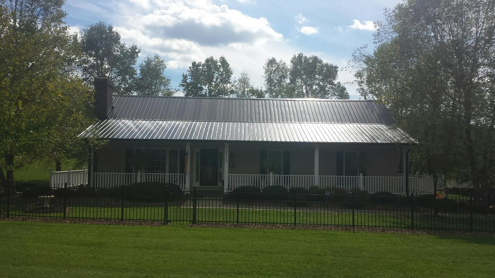 Gray metal roof on a brick ranch with a full width front porch — Gutter Guard Installation work by our crew in Camas