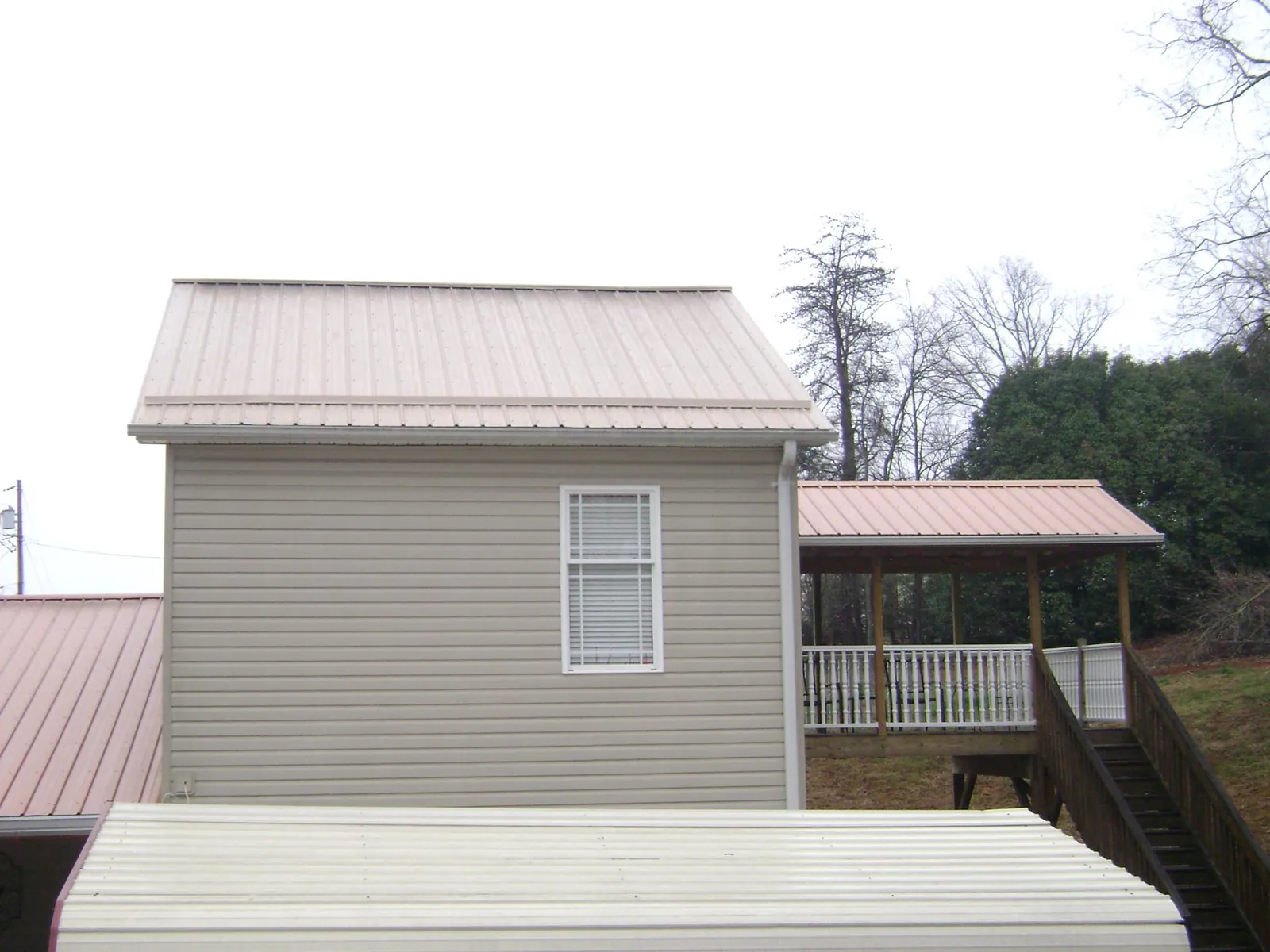 Tan metal roofs on a two story addition and attached porch, from a Roof Replacement job in Camas