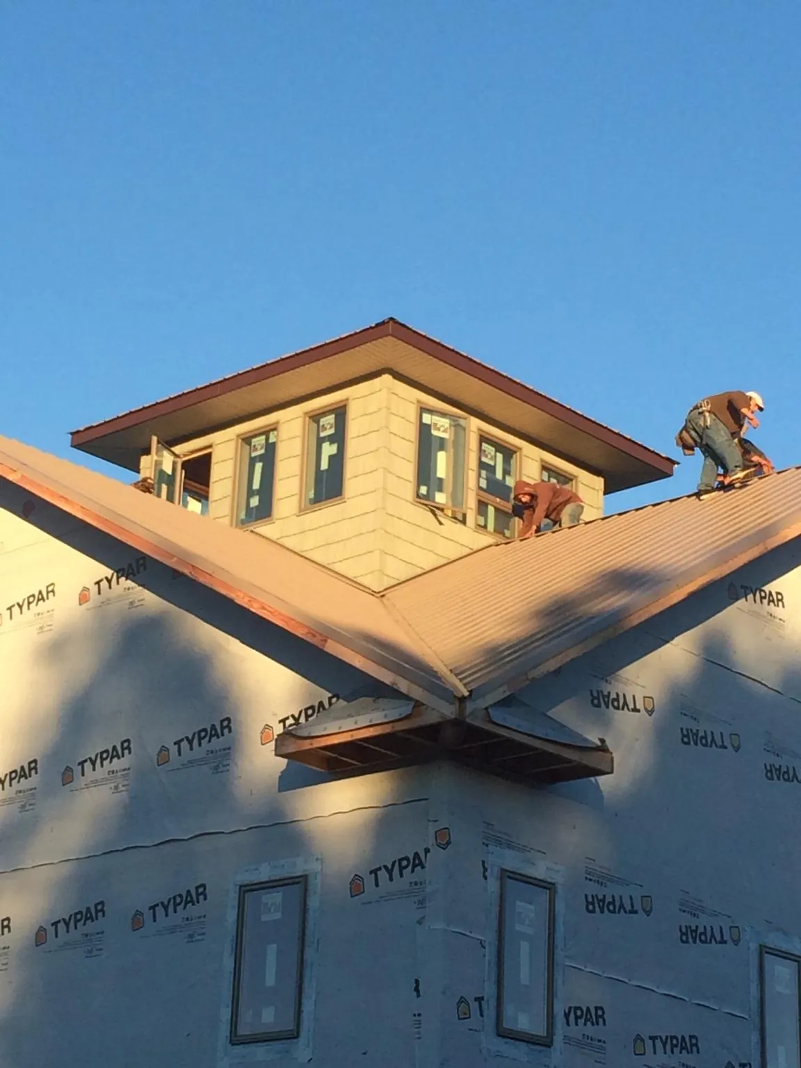 Roofers working around a rooftop cupola on a new metal roof at sunset — Roof Waterproofing in Camas by Roofing Brothers